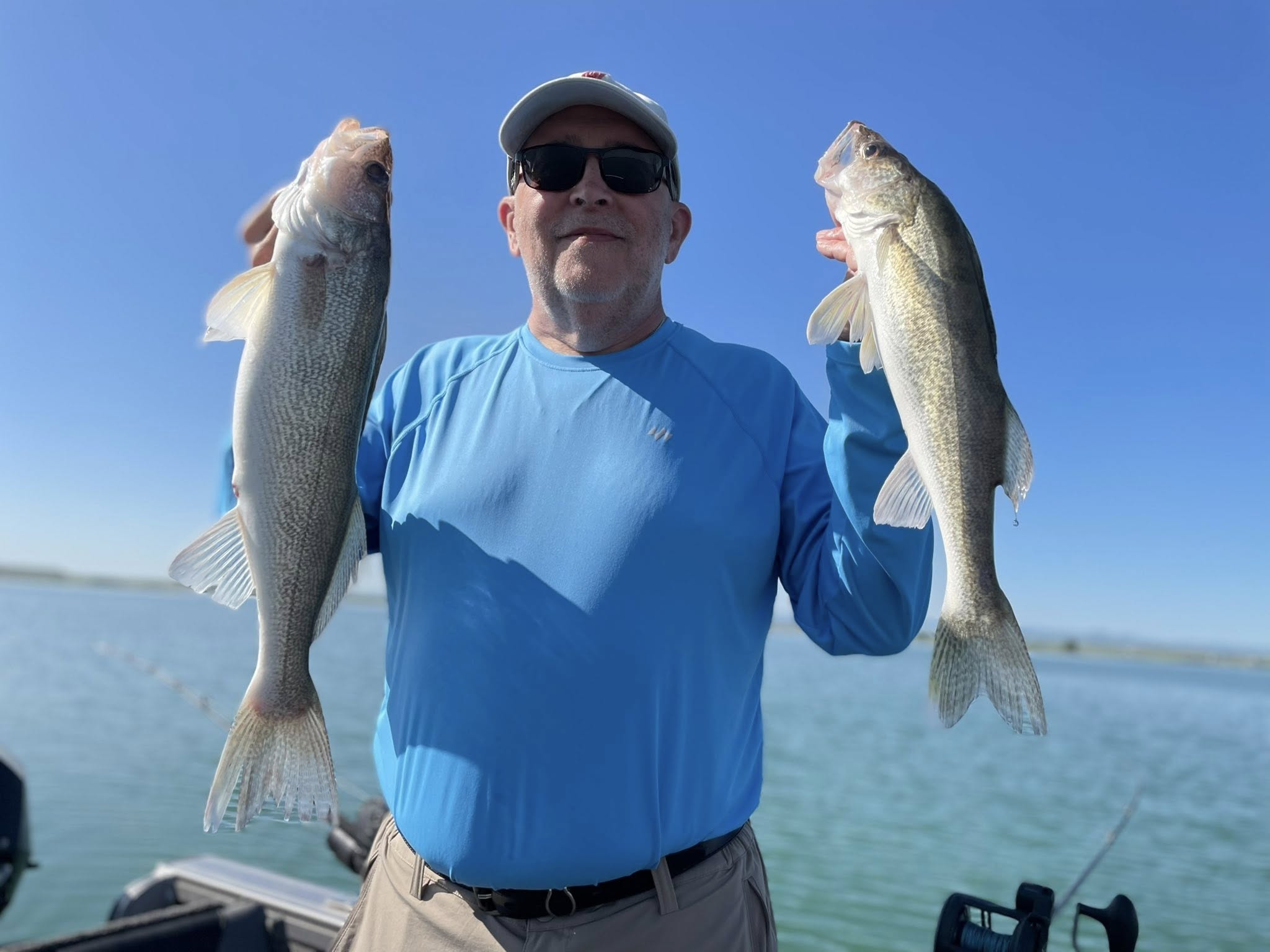Photo of angler holding 2 sauger fish caught in SD