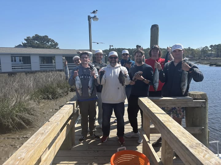 Fishing group celebrating successful catch on wooden dock in Calabash NC with 2 species caught