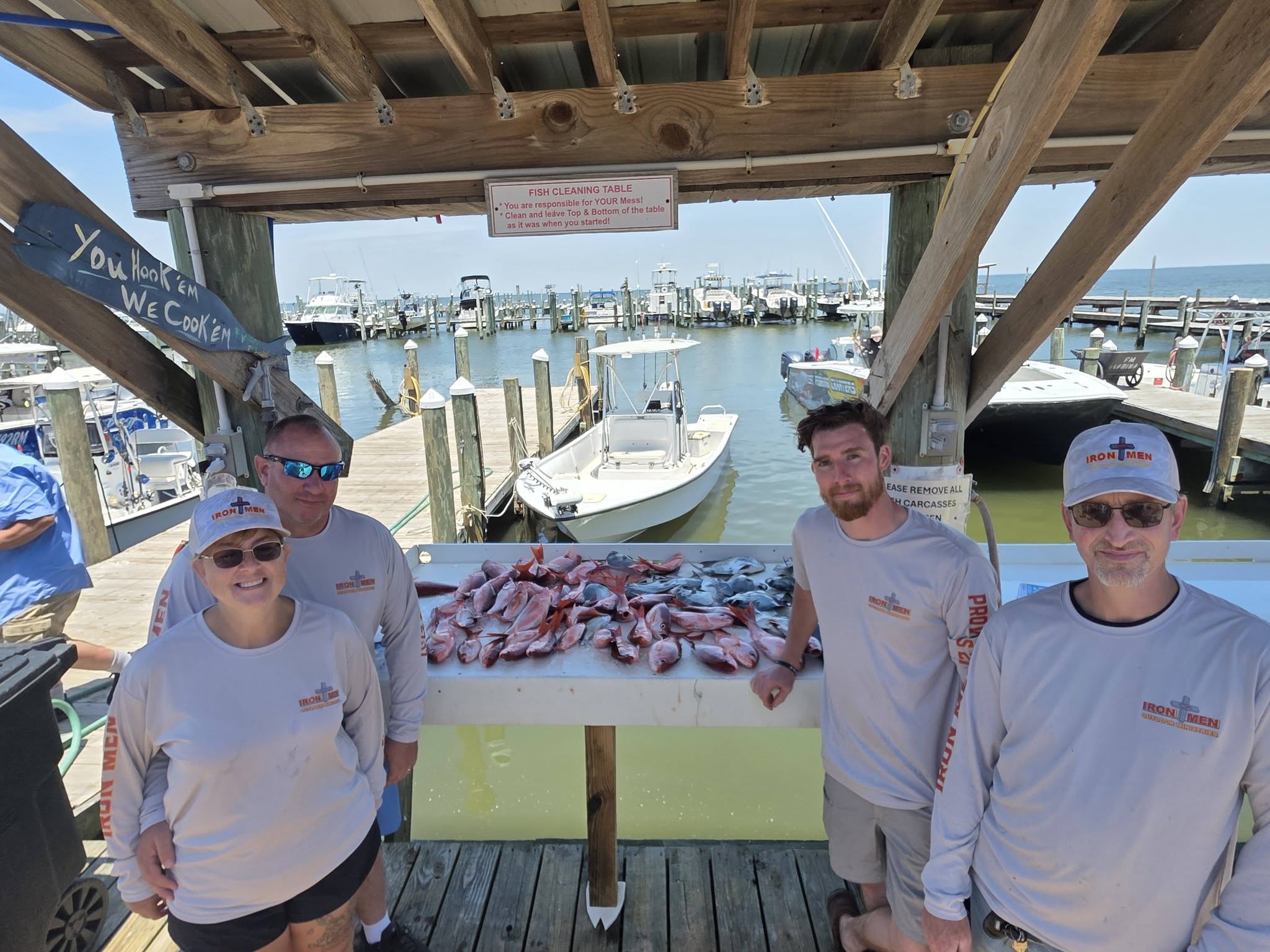 Fresh caught fish displayed on cleaning table at Gulf Shores Alabama marina with boats in background