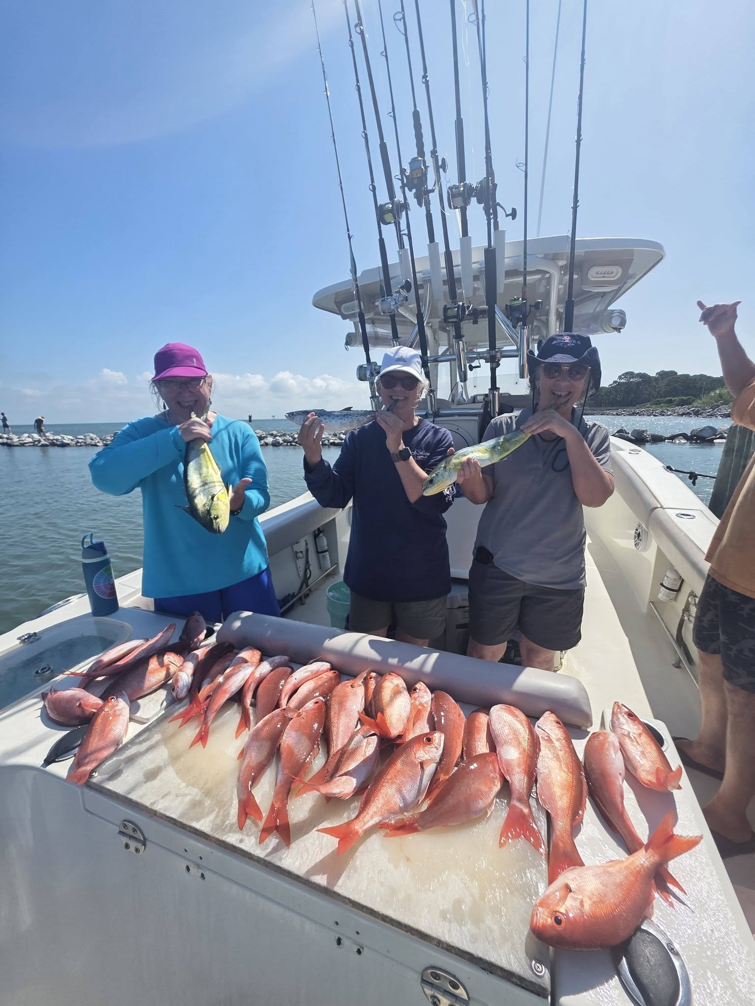 Successful fishing trip in Gulf Shores AL with large catch of red snapper and mahi mahi displayed on boat deck