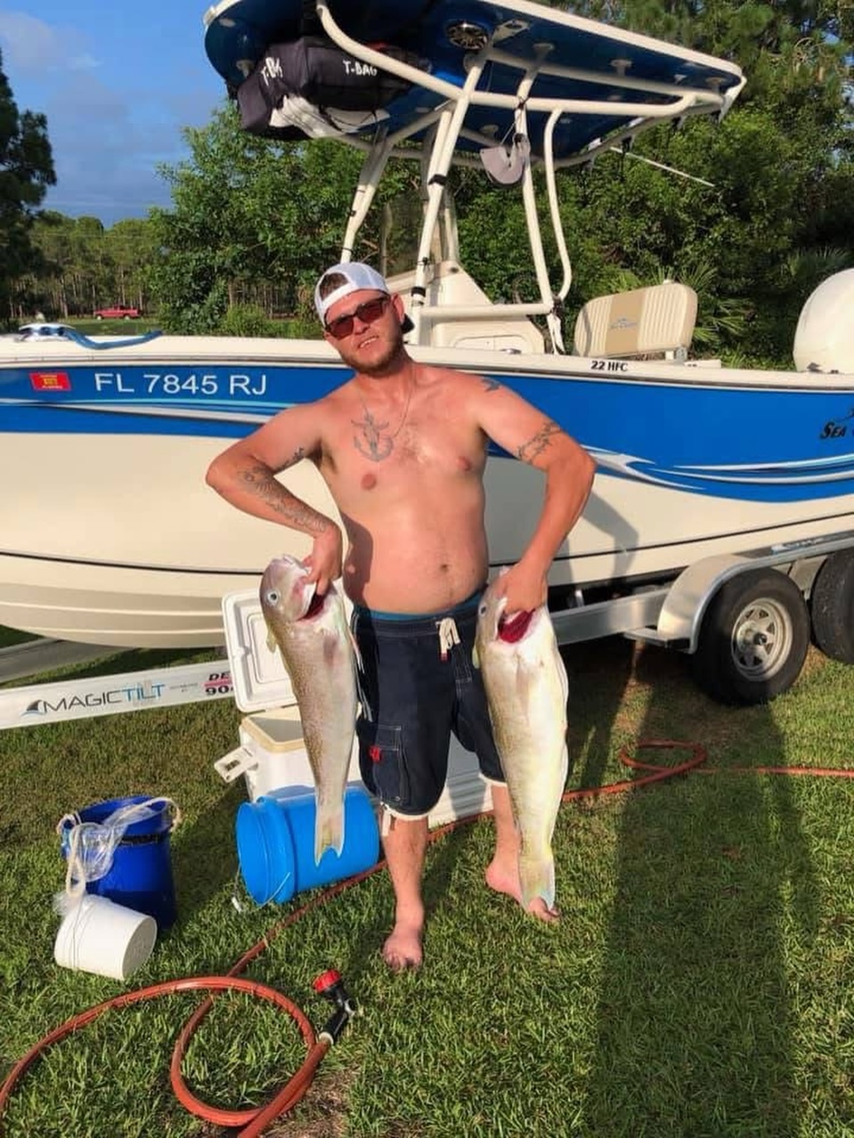 Two large fish caught during fishing trip in Grant-Valkaria FL with boat and trailer in background