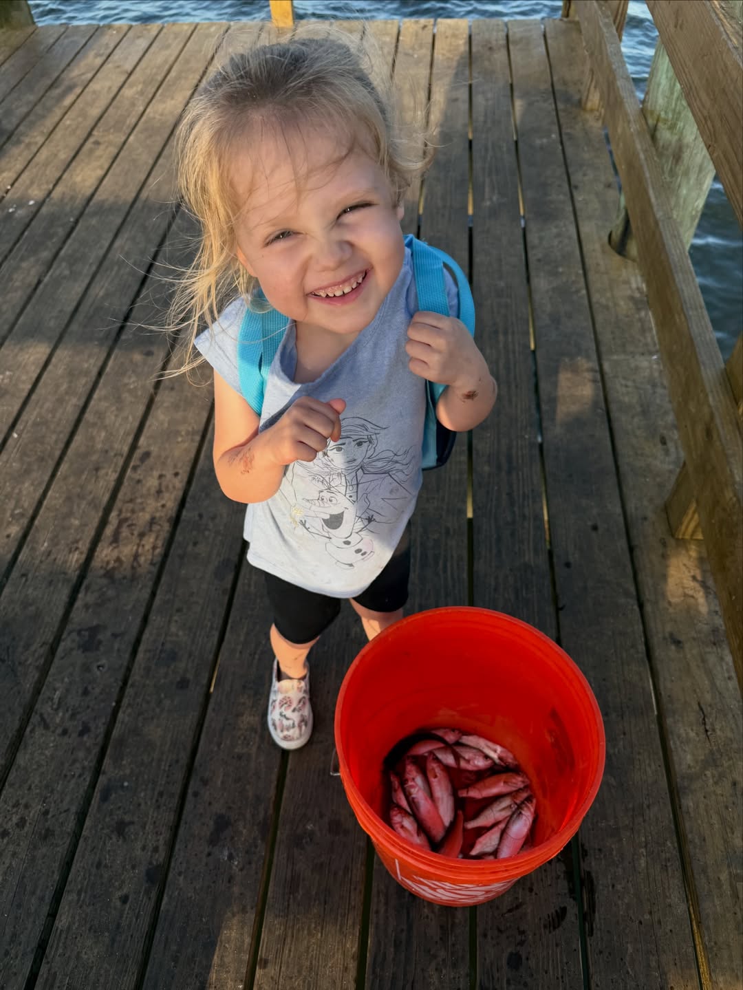 Fresh caught fish displayed in red bucket on wooden dock in Grant-Valkaria FL