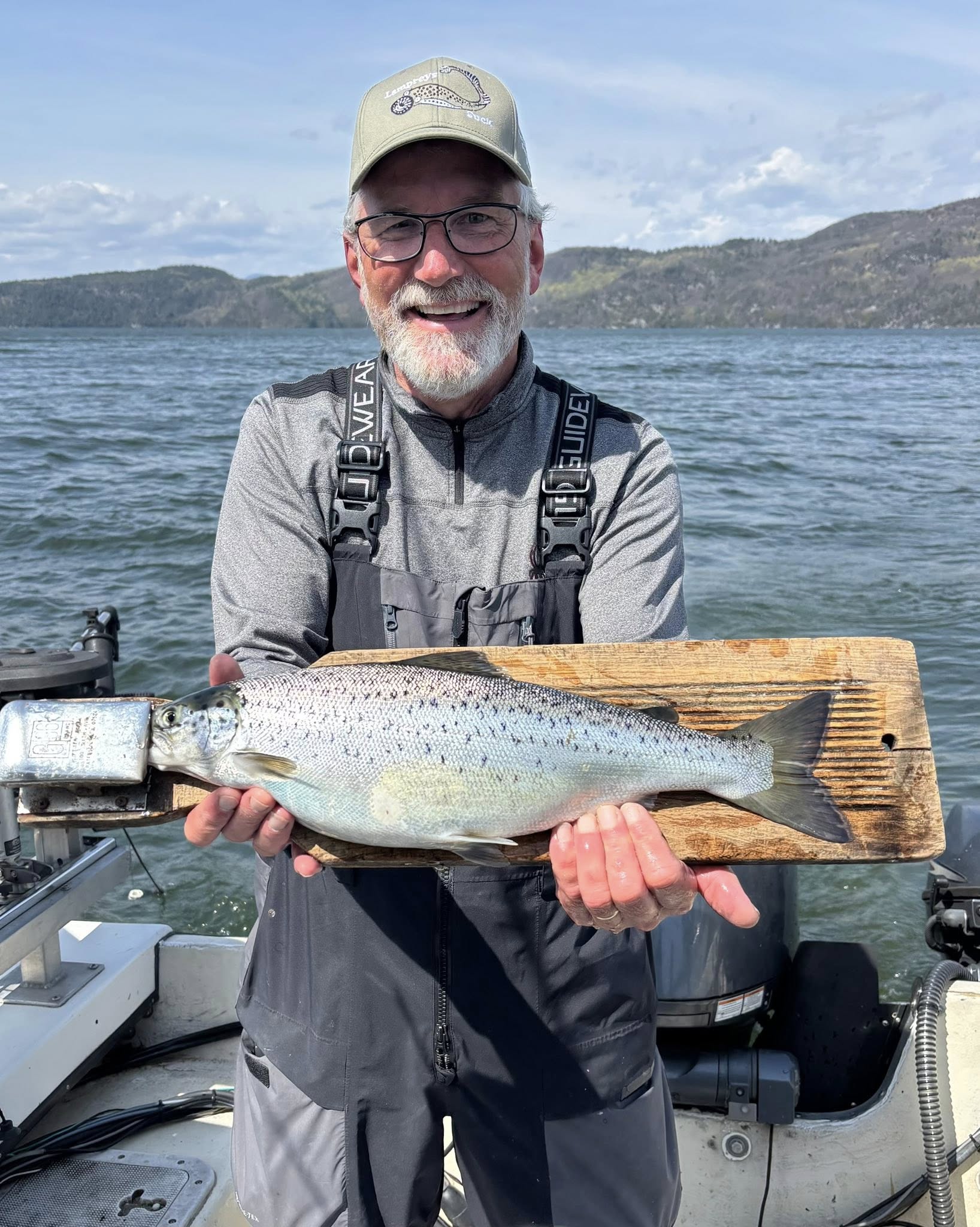 Atlantic salmon caught while fishing in Burlington VT displayed on wooden measuring board on boat