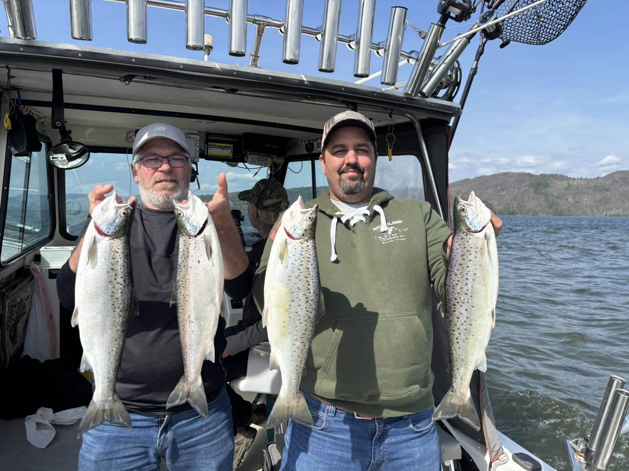 Two anglers displaying four Atlantic salmon caught while fishing in Burlington VT