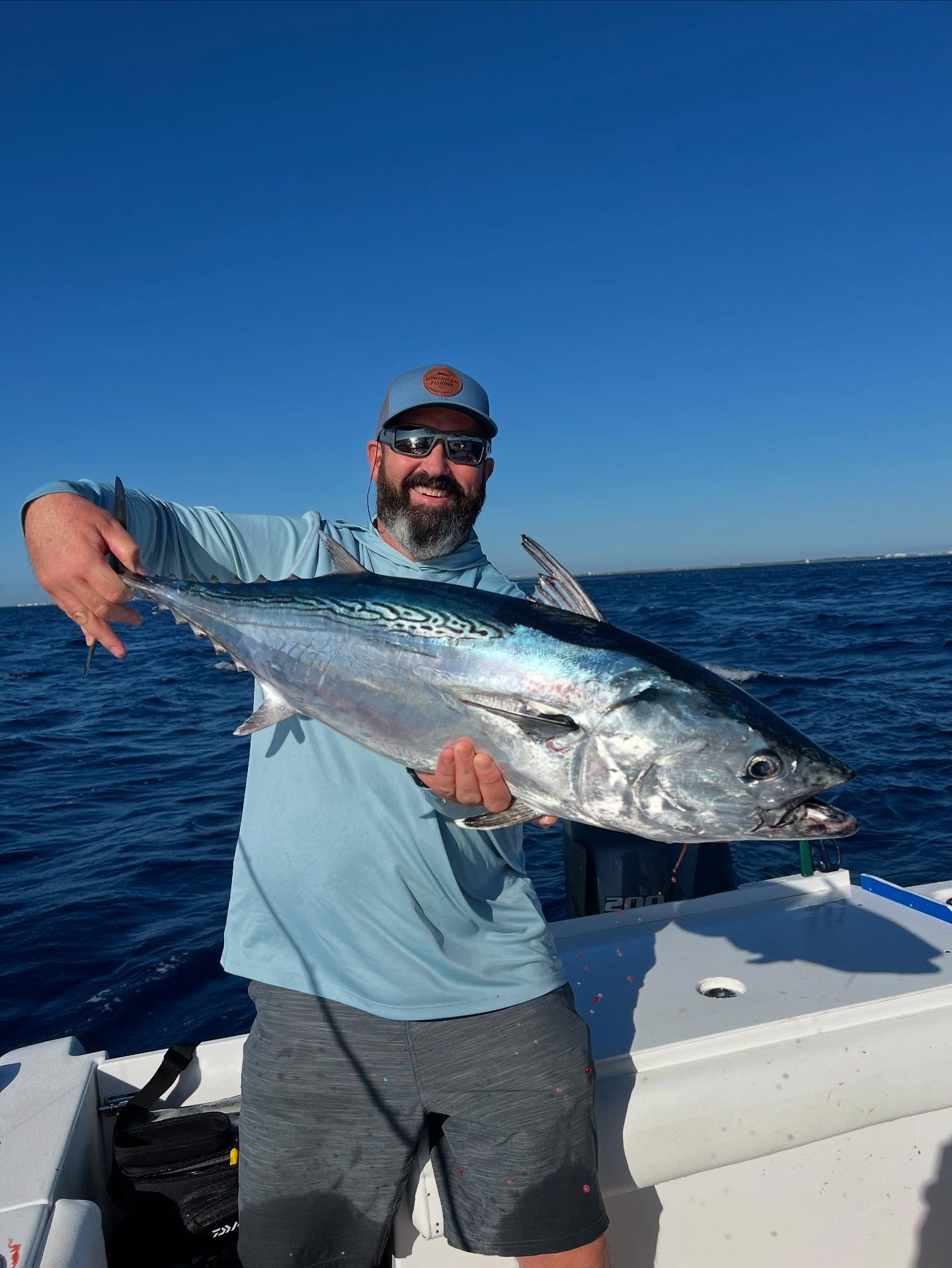 A fisherman catching a little tunny, a 30-inch fish, in Jupiter