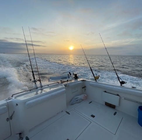 Fishing boat with multiple rods at sunset on ocean waters near Fort Walton Beach FL
