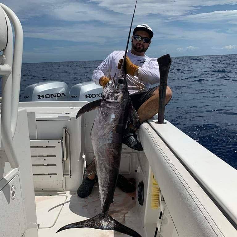 Photograph of a fisherman with a large blue marlin in Fort Lauderdale