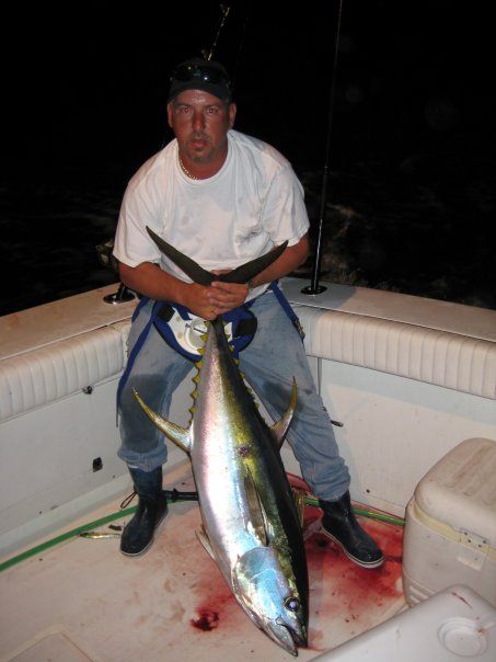 A fisherman holding a large yellowfin tuna in League City