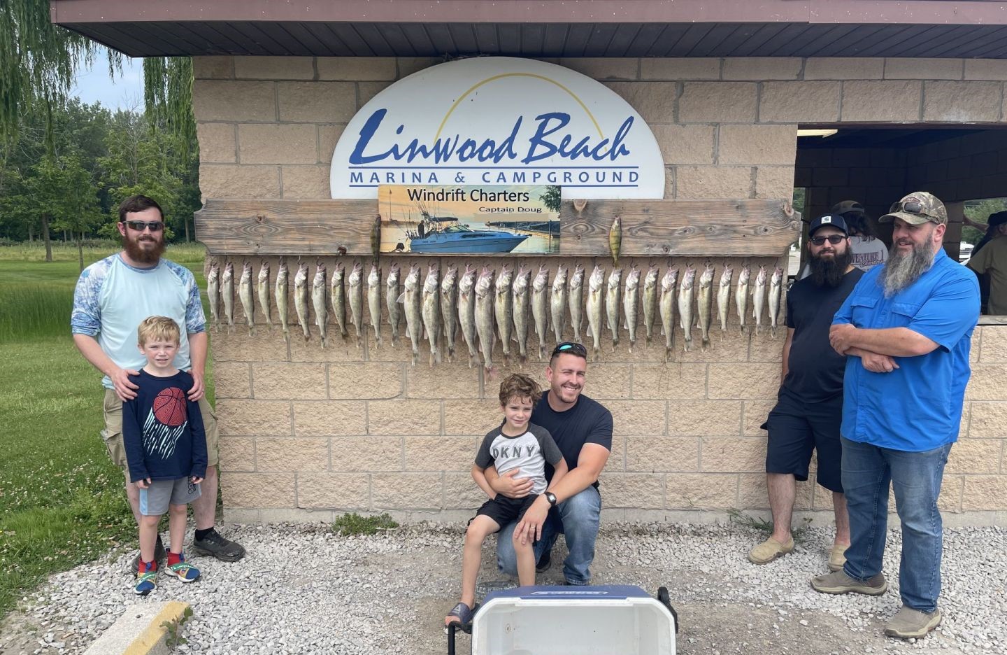 Successful fishing trip display at Linwood Beach Marina with multiple caught fish hung on cleaning station