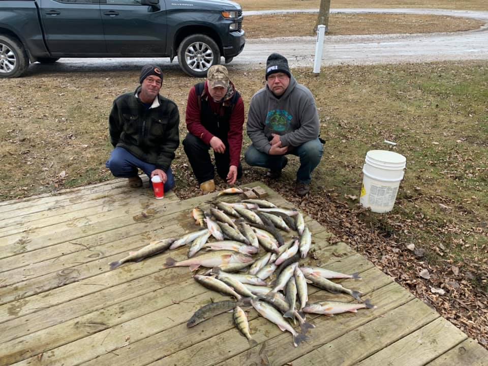 Large catch of fish displayed on wooden dock in Linwood MI after successful fishing trip