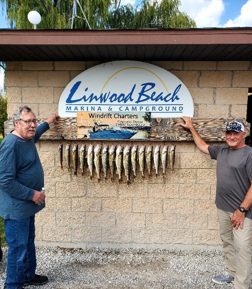 Two anglers displaying their walleye catch at Linwood Beach Marina in Michigan