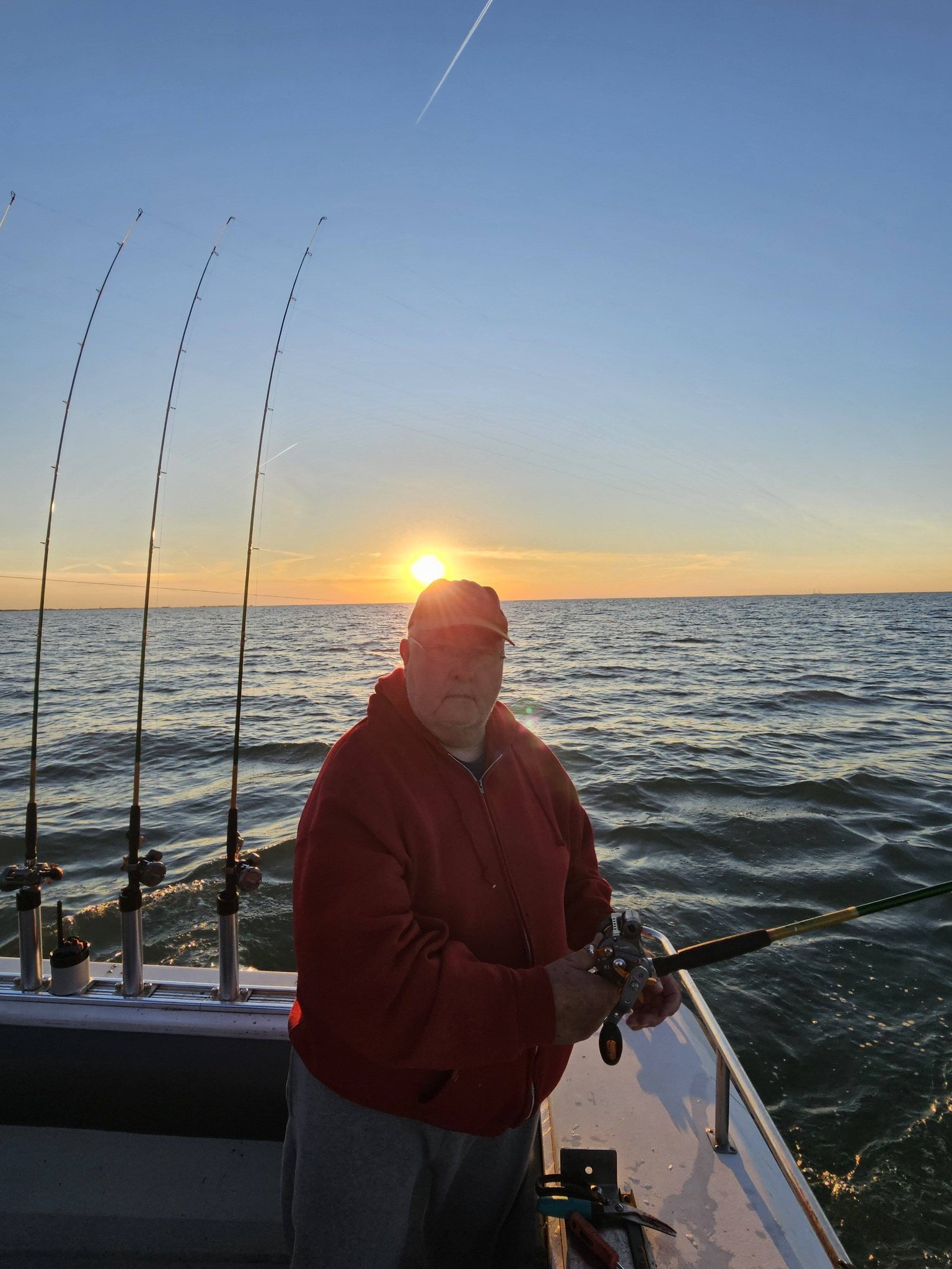 Fishing charter boat at sunrise in Port Clinton OH with multiple fishing rods set up for trolling