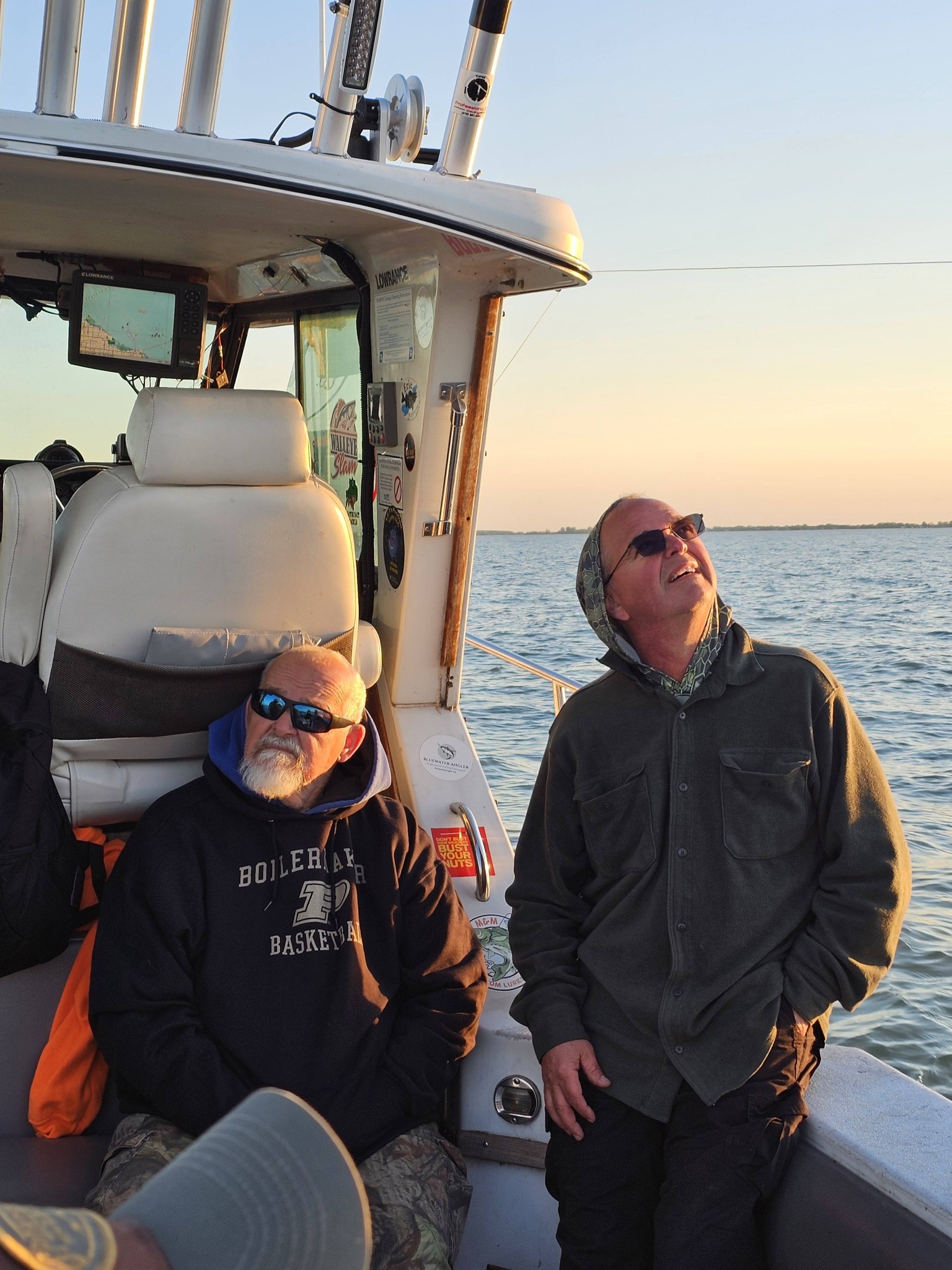 Two anglers on fishing boat during sunset in Port Clinton OH waters