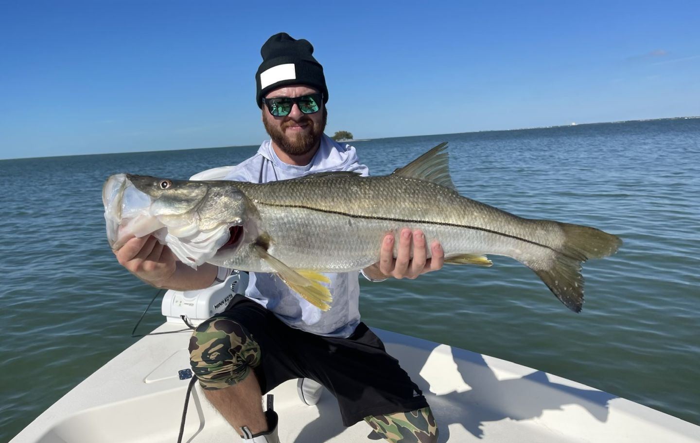 A fisherman holding a large snook caught in Tarpon Springs, Florida