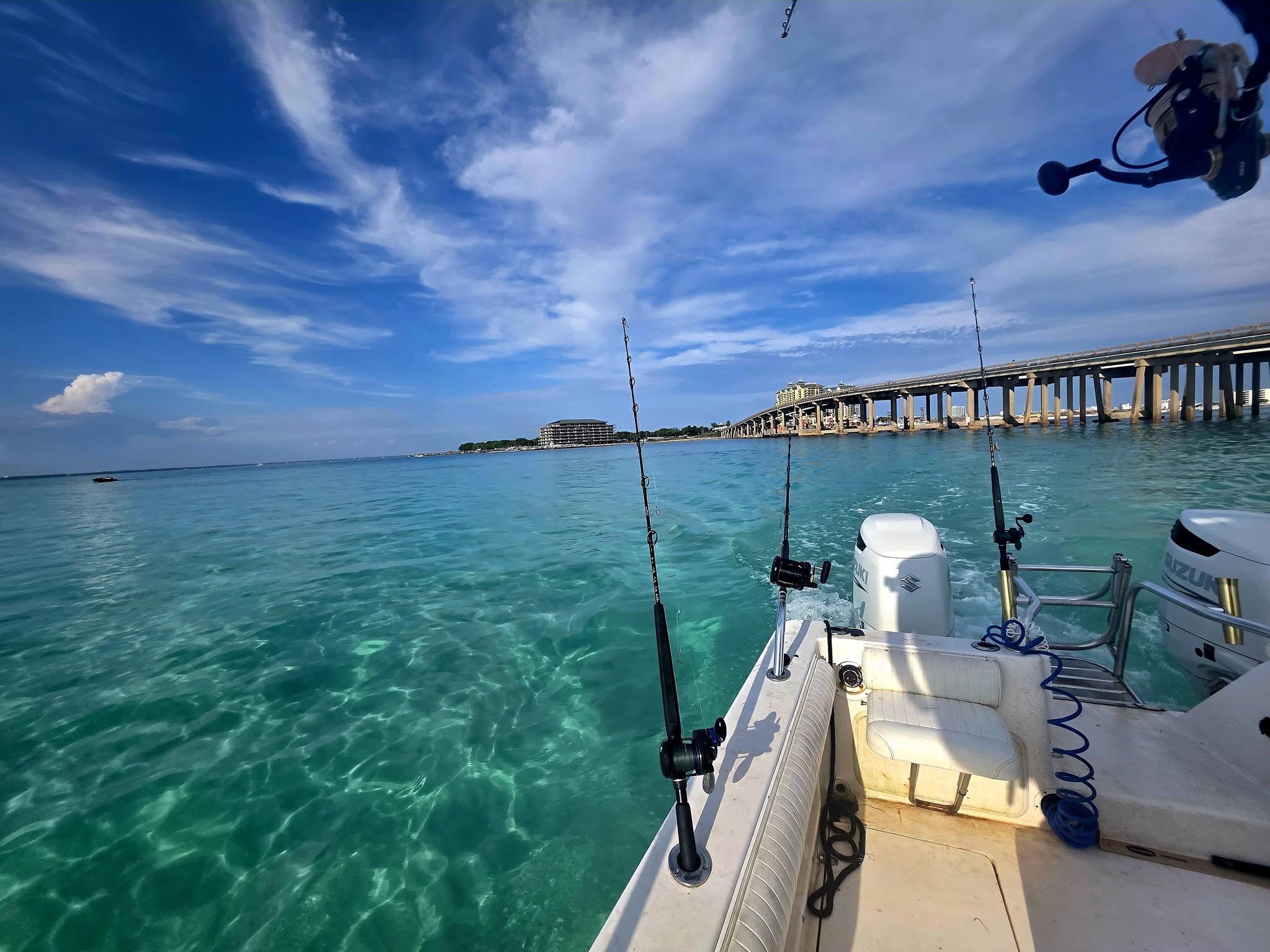 Fishing boat with rods ready on turquoise waters near Gulf Breeze FL bridge