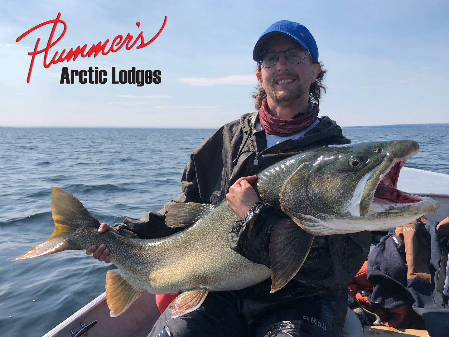 A person fishing in Yellowknife, holding a 15-inch fish