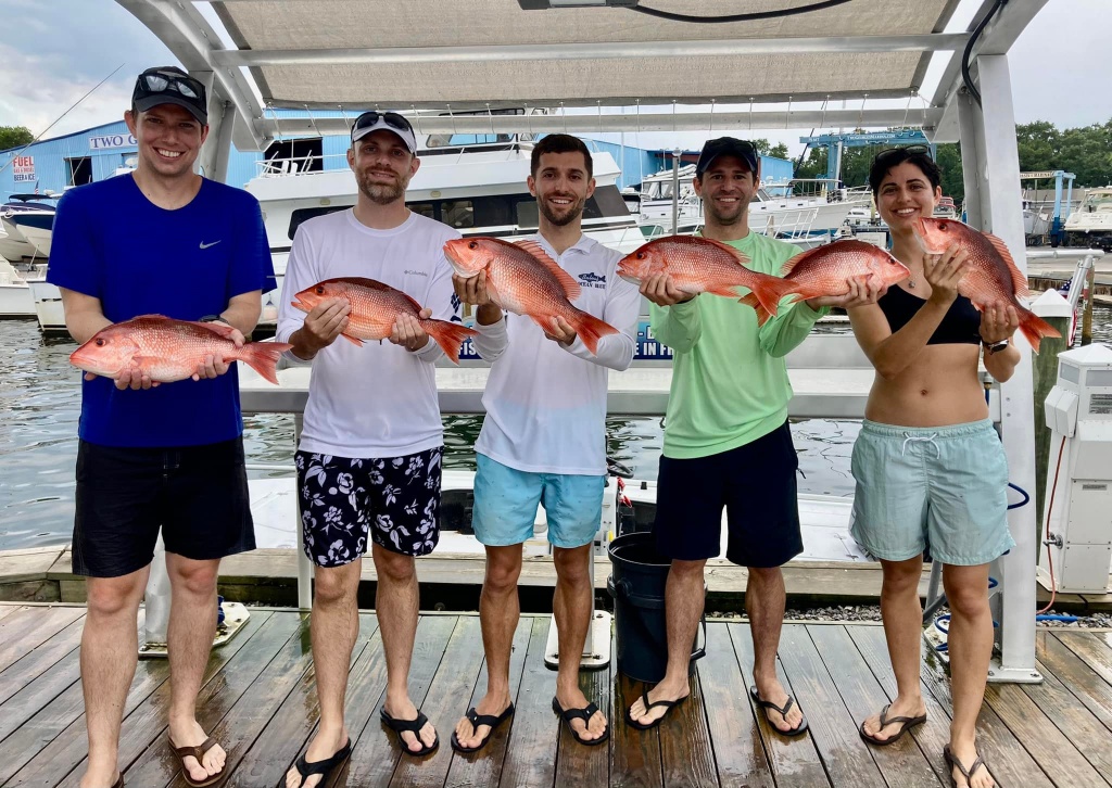 5 people proudly holding their fishing catch in Shalimar