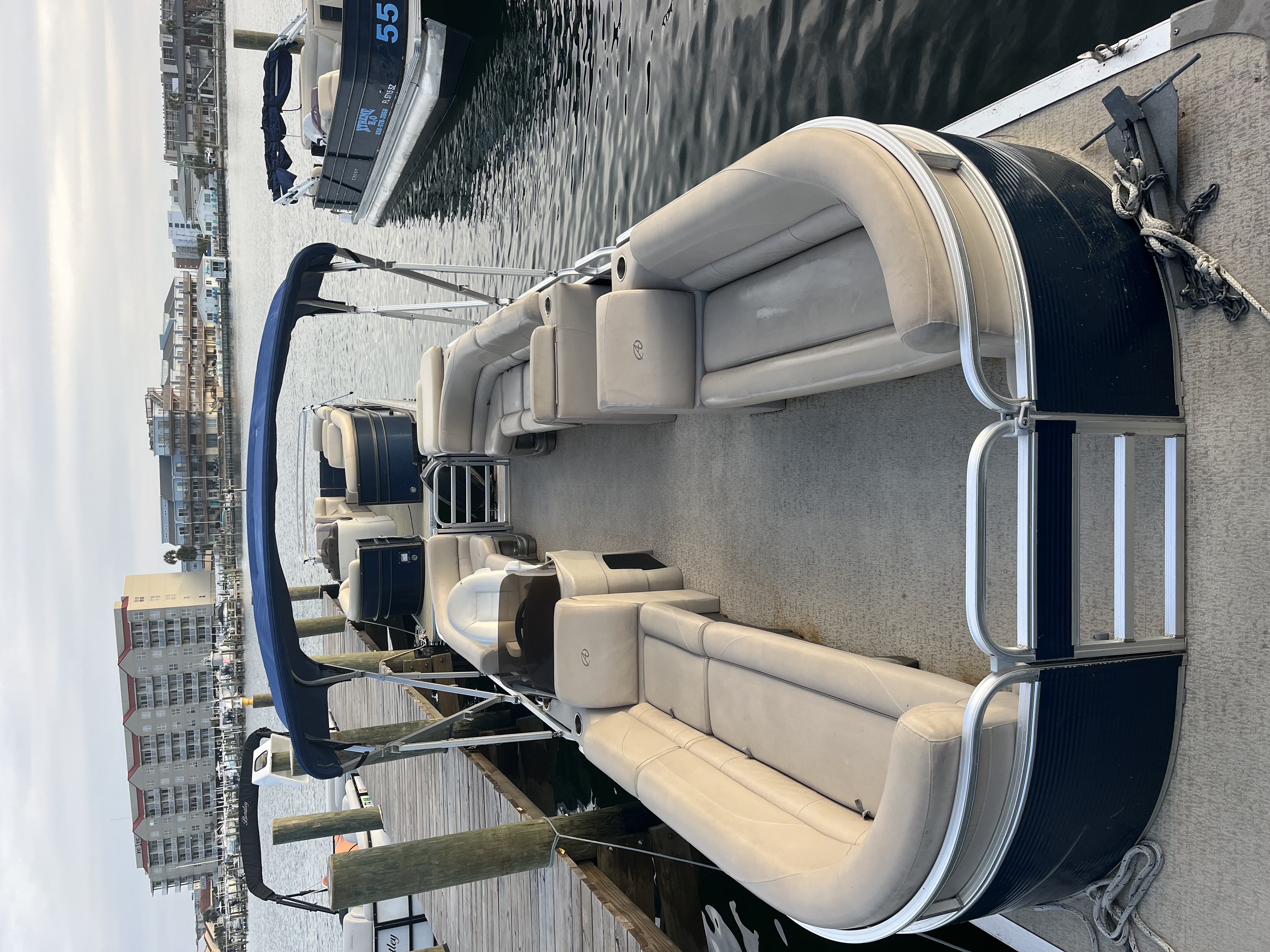 Luxury pontoon boat with comfortable seating docked at marina