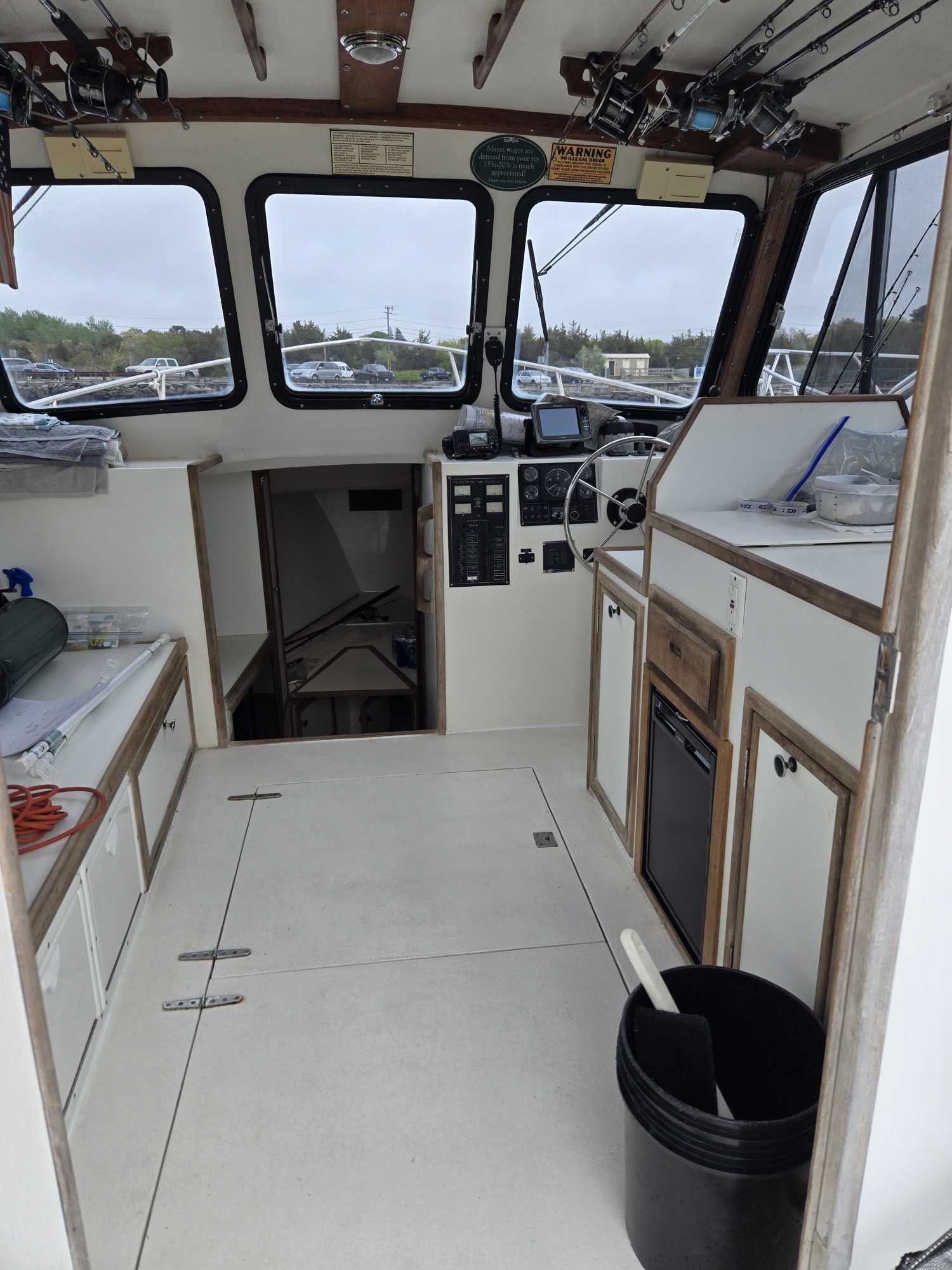 Interior of fishing boat cabin showing helm station, navigation equipment, and galley area at Cape Cod MA marina