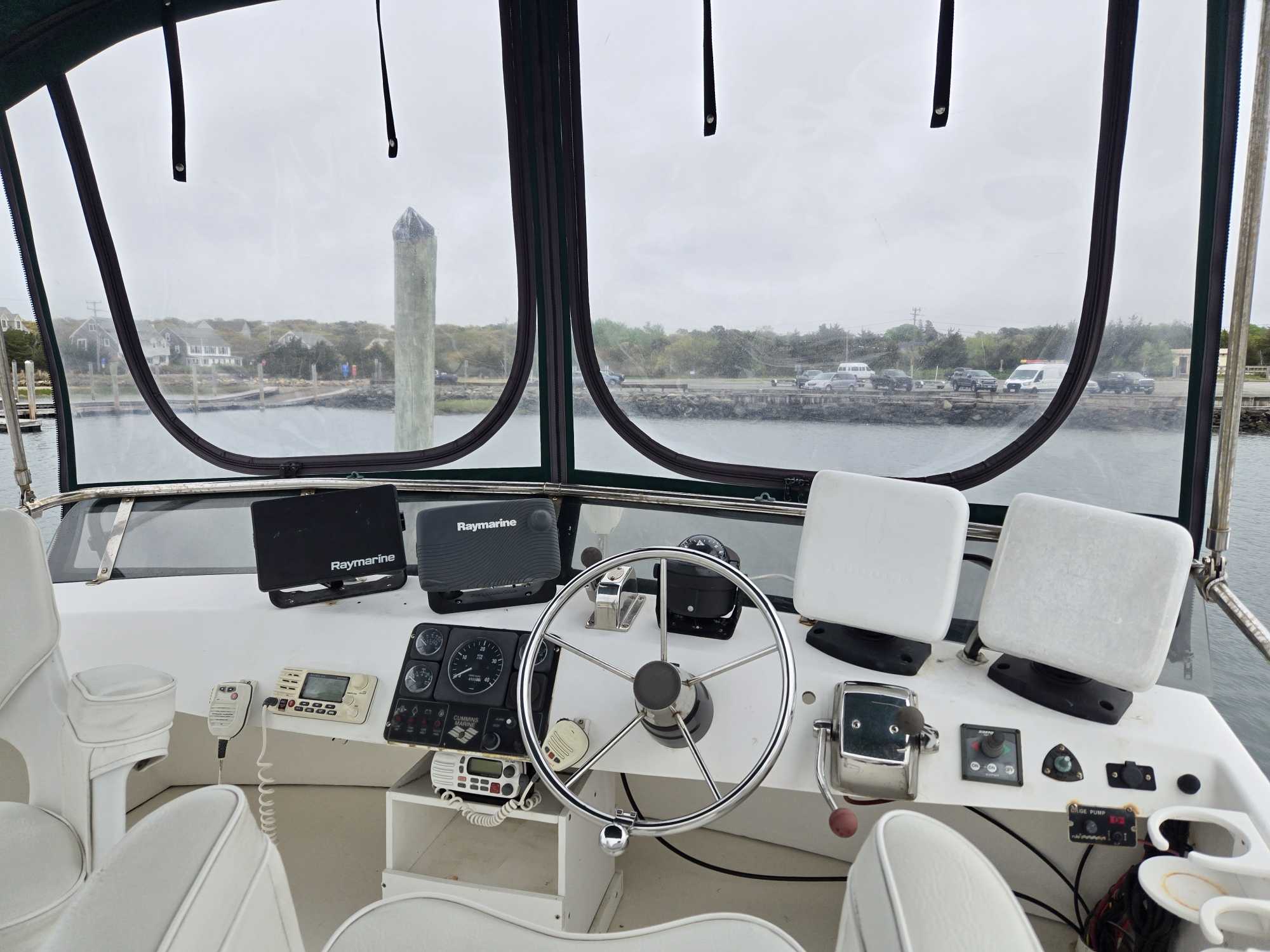 Fishing boat helm with steering wheel, navigation equipment, and Raymarine displays on Cape Cod MA