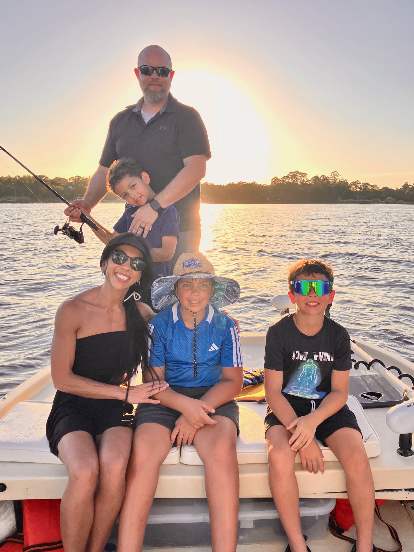 Family fishing trip on boat at sunset in Bagdad FL waters