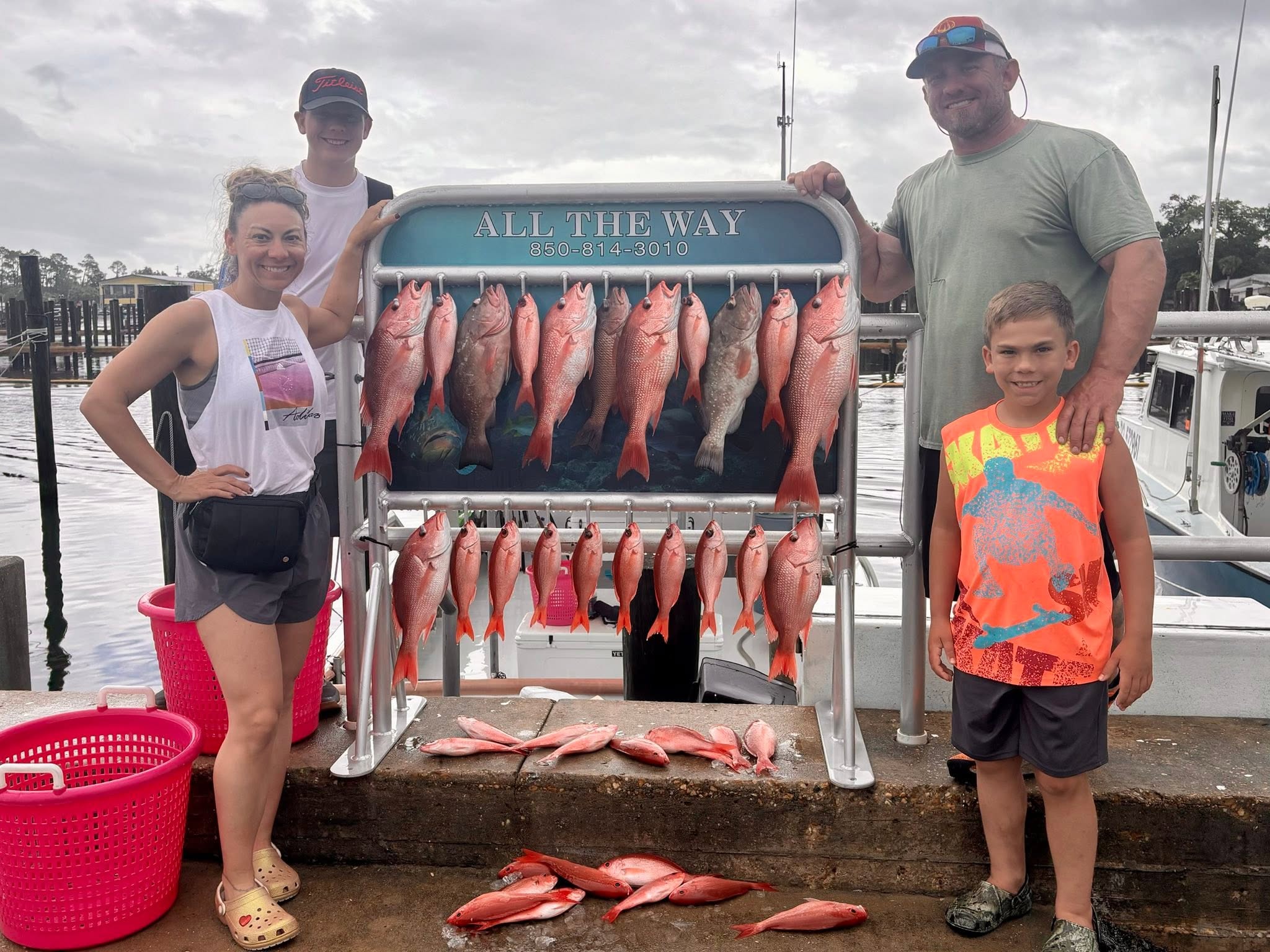 Successful red snapper and red grouper fishing trip display at Panama City FL marina with multiple fish hung on cleaning station