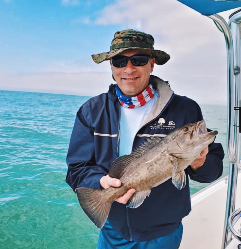 An angler holding a 16-inch fish in Clearwater