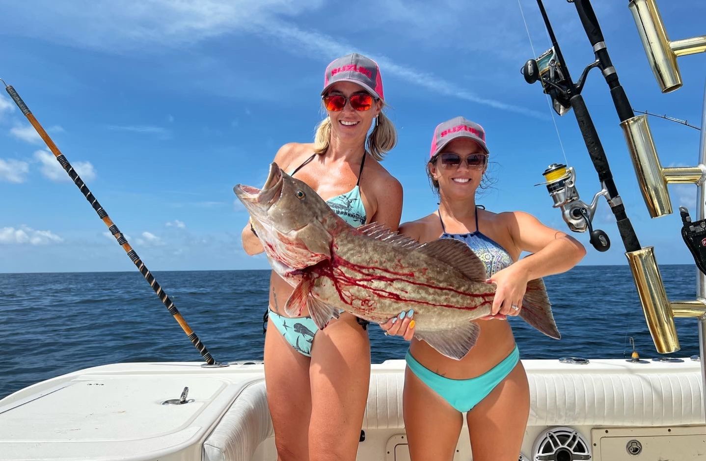 Two people fishing in Destin with a 23-inch fish