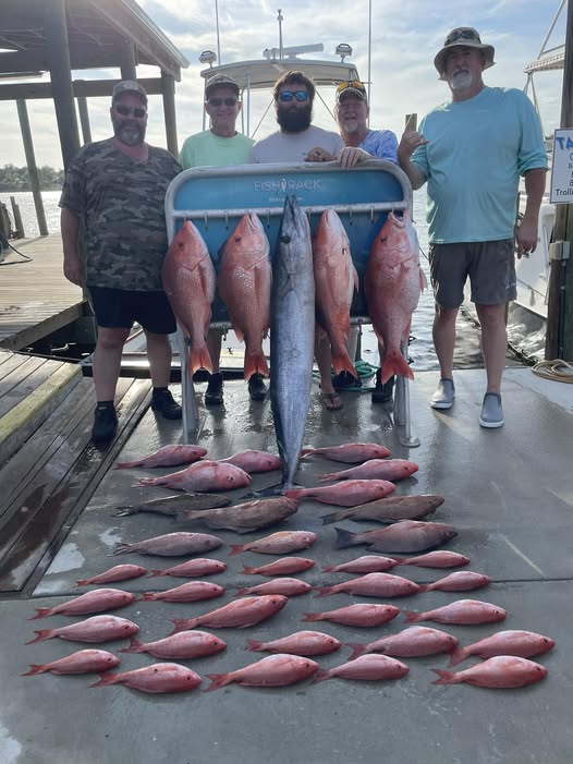 Successful fishing charter displaying red snapper and wahoo catch on boat dock in Panama City Beach FL