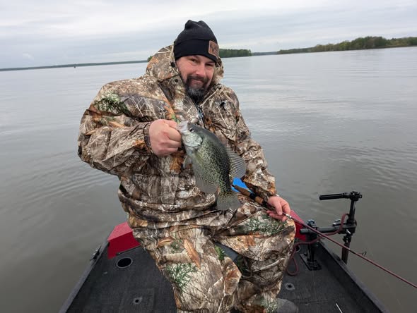 Angler holding freshly caught crappie on fishing boat in Foxburg PA