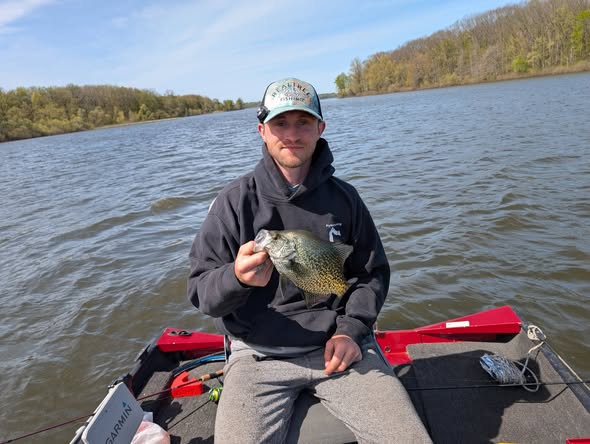 Angler holding freshly caught fish while fishing on lake in Foxburg PA