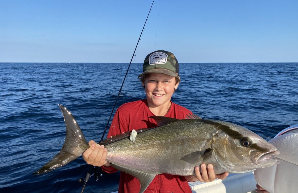 A fisherman holding a large greater amberjack fish in Wilmington