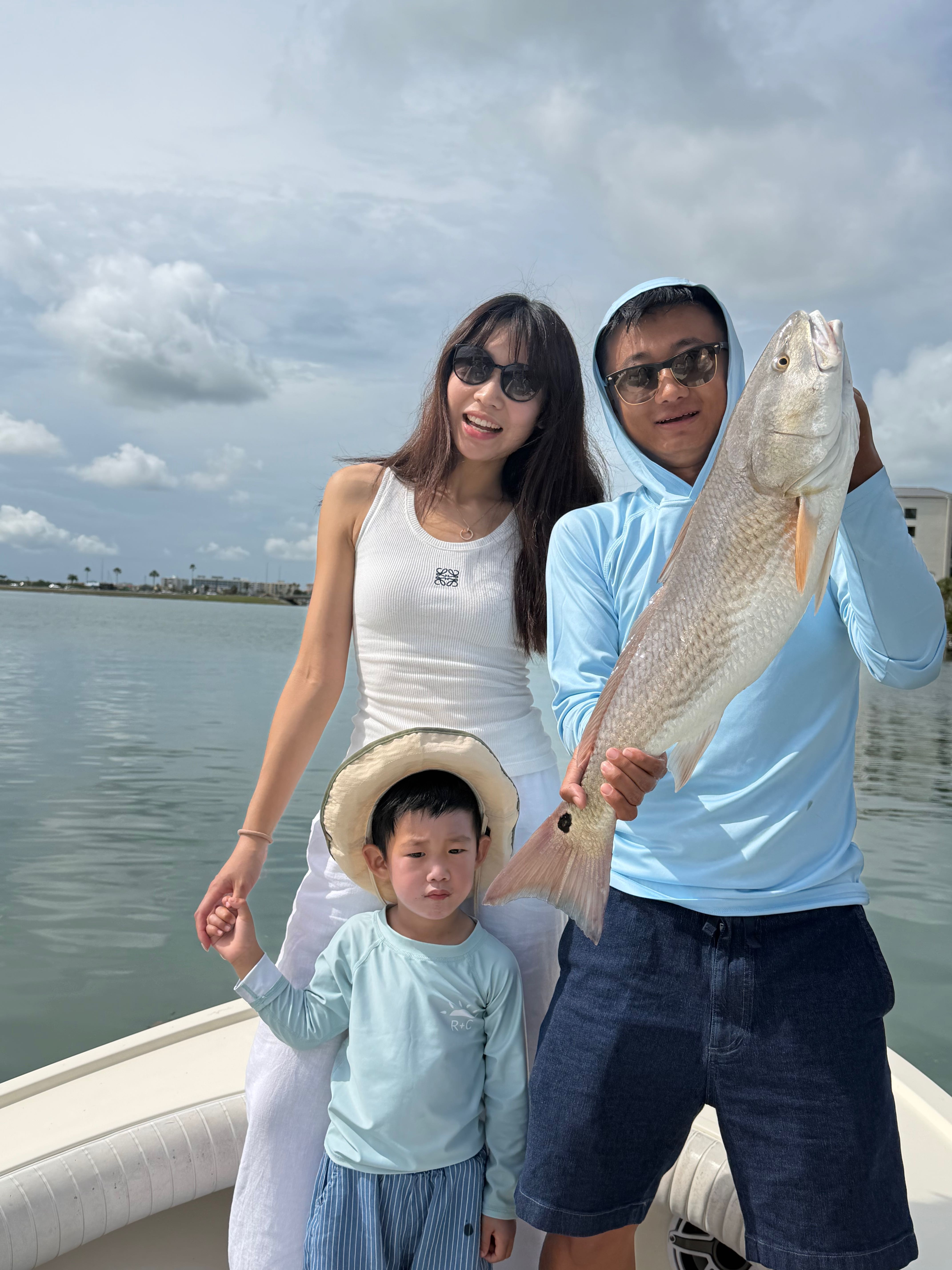 Family fishing trip in Clearwater FL with freshly caught redfish on boat
