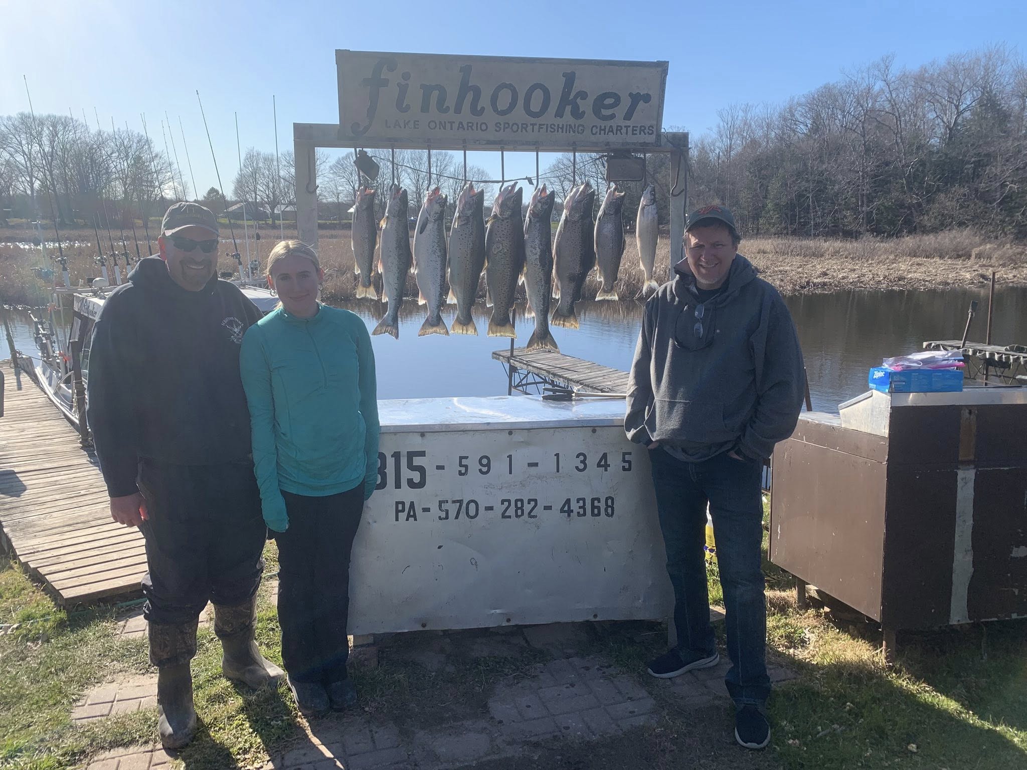 Atlantic salmon fishing charter display with multiple caught fish hanging on rack at Mexico NY fishing dock