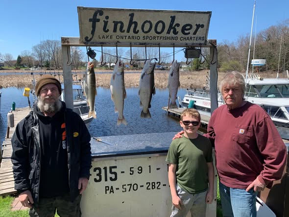 Four Chinook salmon hanging from fishing charter display board at Lake Ontario marina in Mexico NY