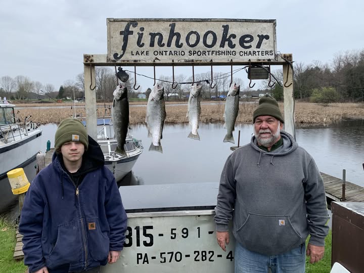 Fishing charter display board showing four caught fish hanging from hooks at Lake Ontario Sportfishing Charters in Mexico NY