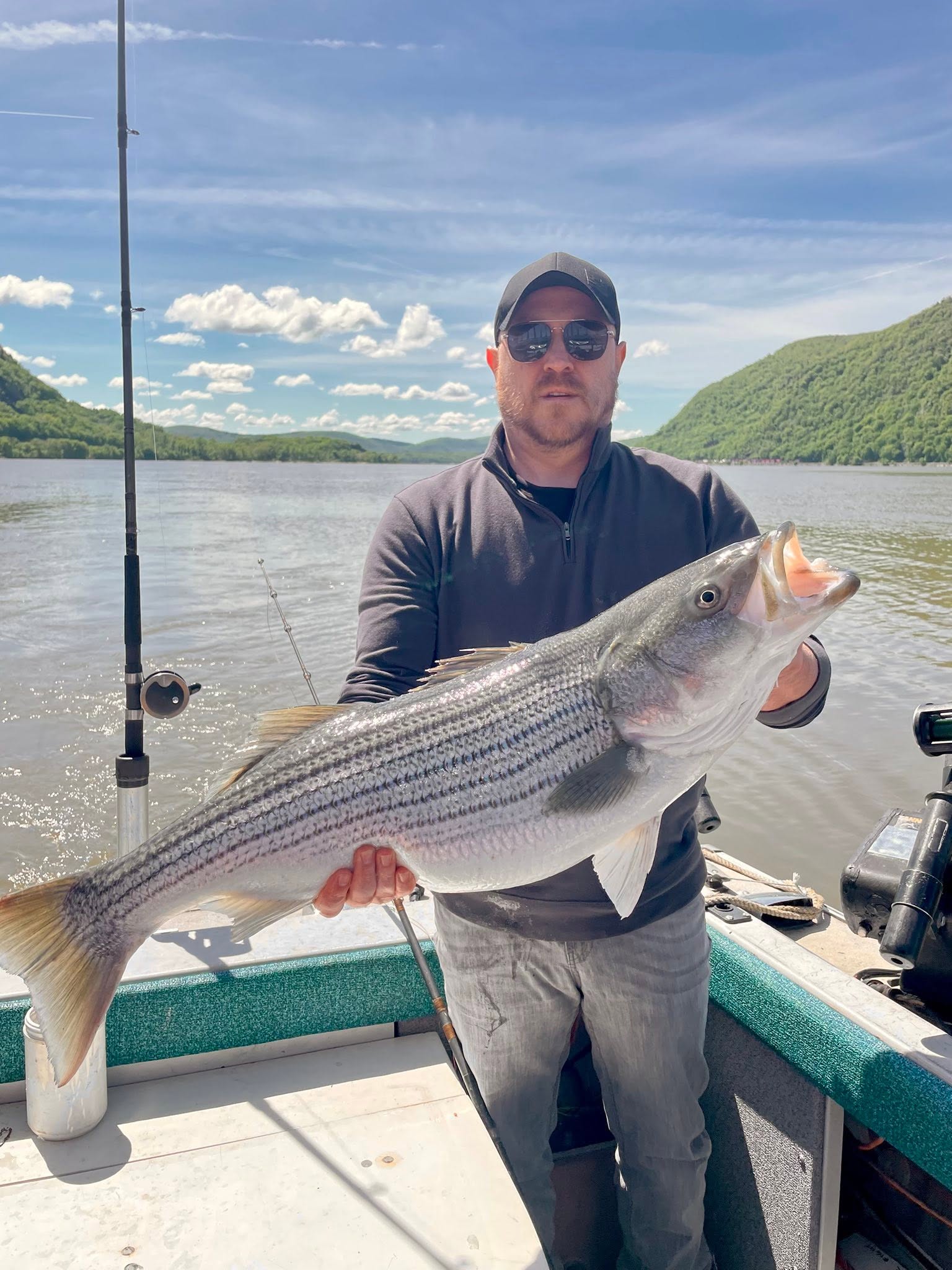 Striped bass catch on fishing boat in Mexico NY with mountain backdrop