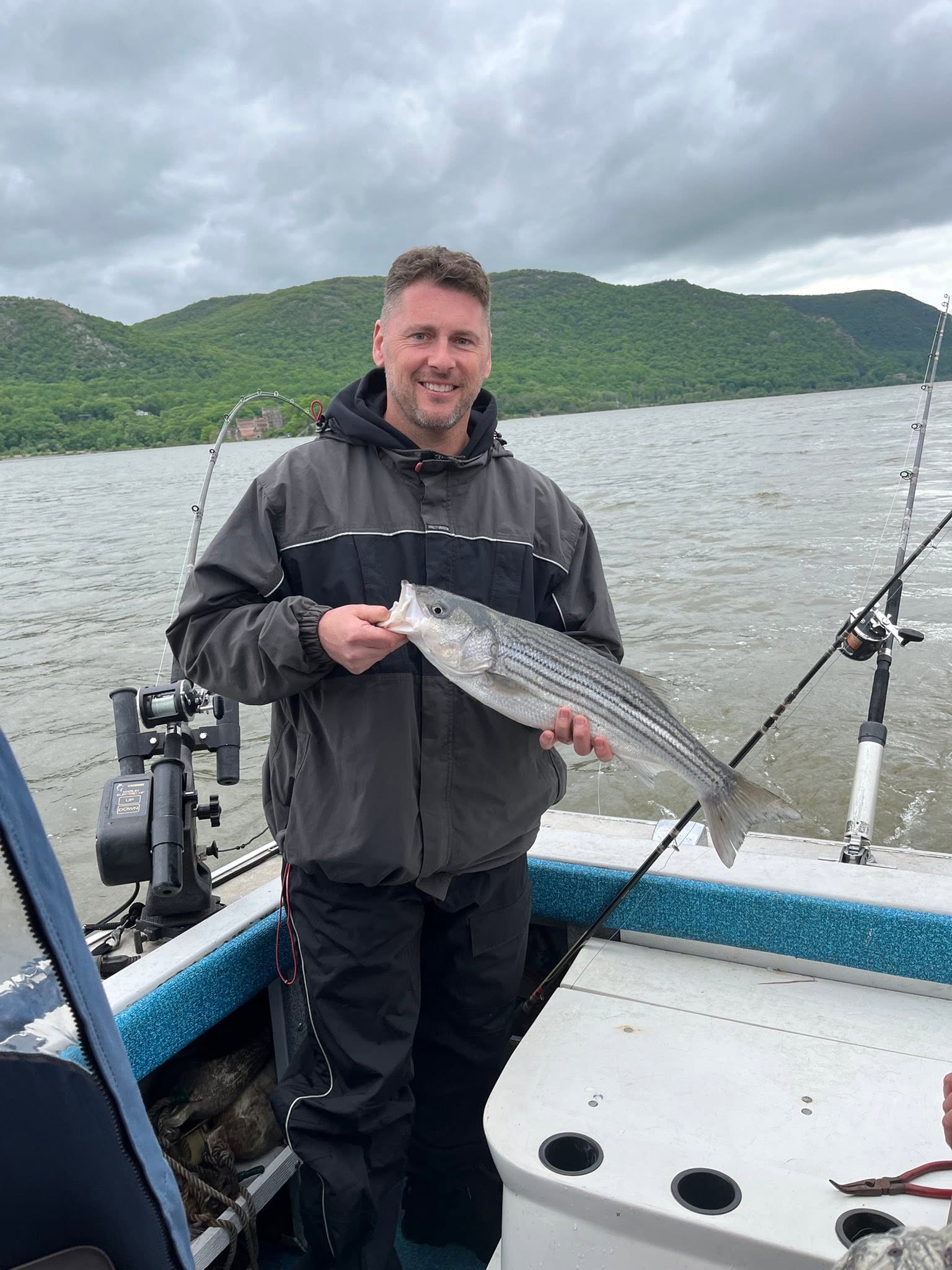 Striped bass caught while fishing on boat in Mexico NY with mountain backdrop