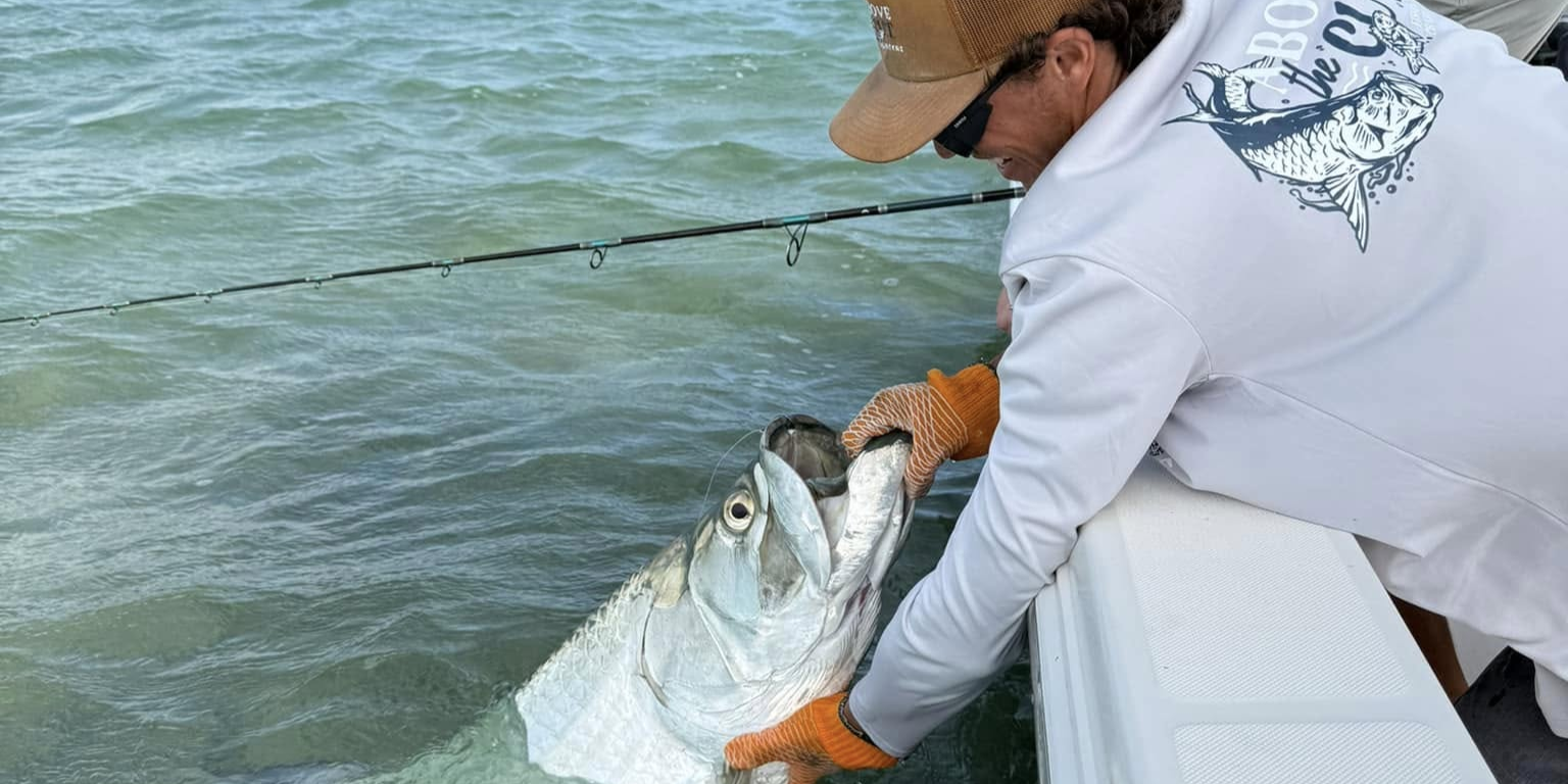 Key West sunset tarpon fishing charter boat at golden hour with anglers casting lines inshore