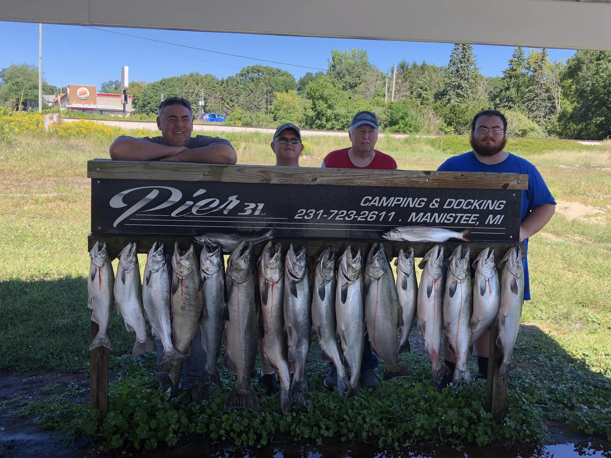Anglers holding a catch of 12 rainbow trout in MI