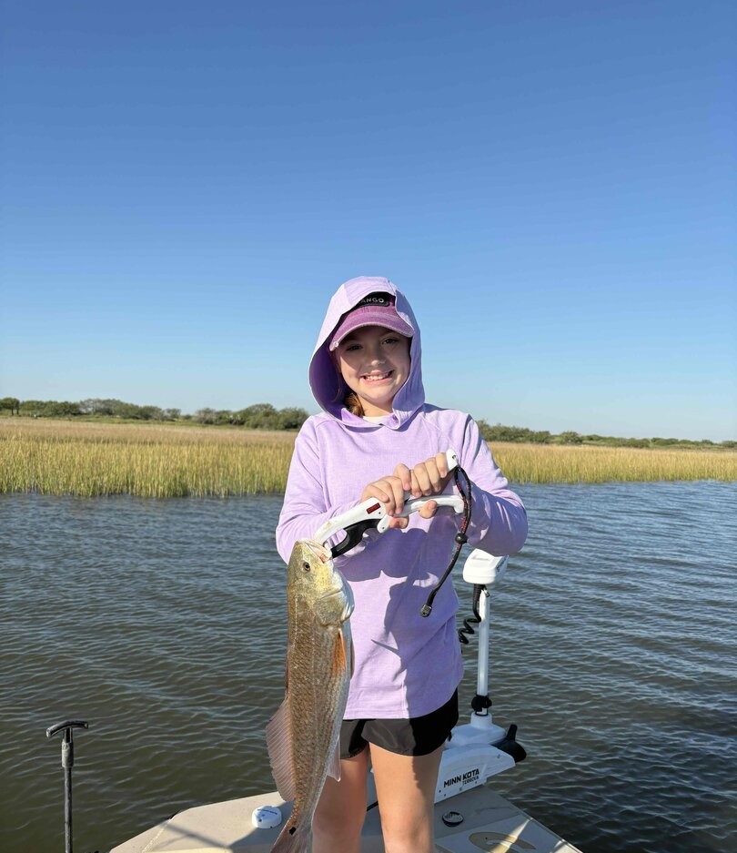 Redfish catch during fishing trip in Palacios TX waters with marsh grass background
