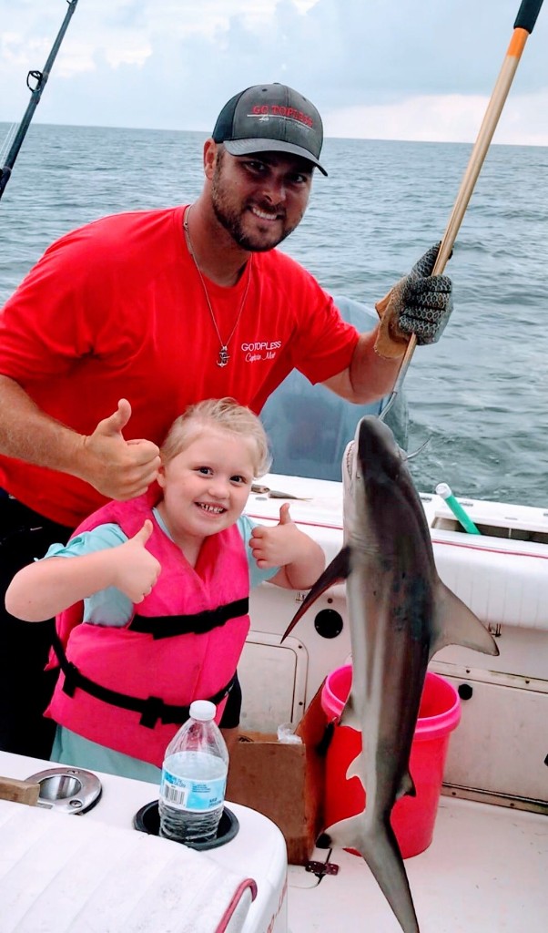 Two people fishing in Biloxi with a 23-inch catch