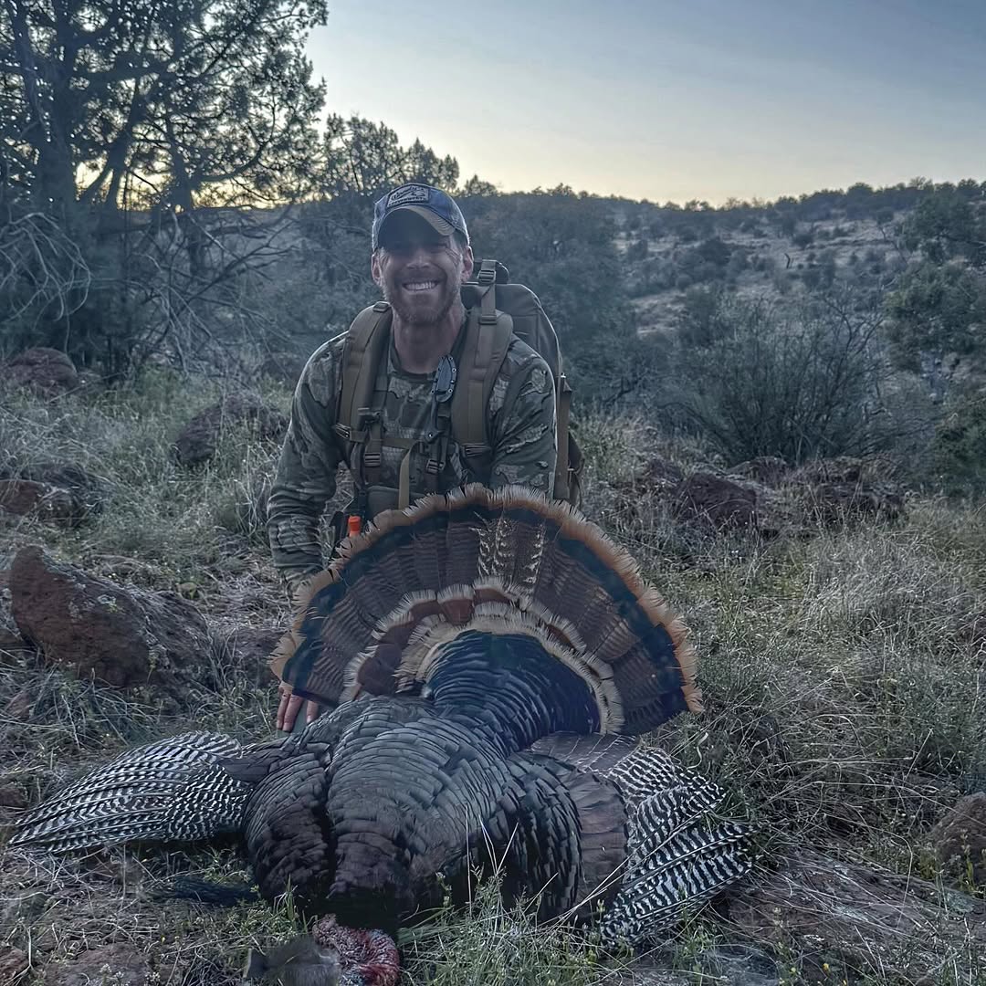 Turkey hunting success in Scottsdale Arizona desert terrain with harvested wild turkey displaying tail feathers