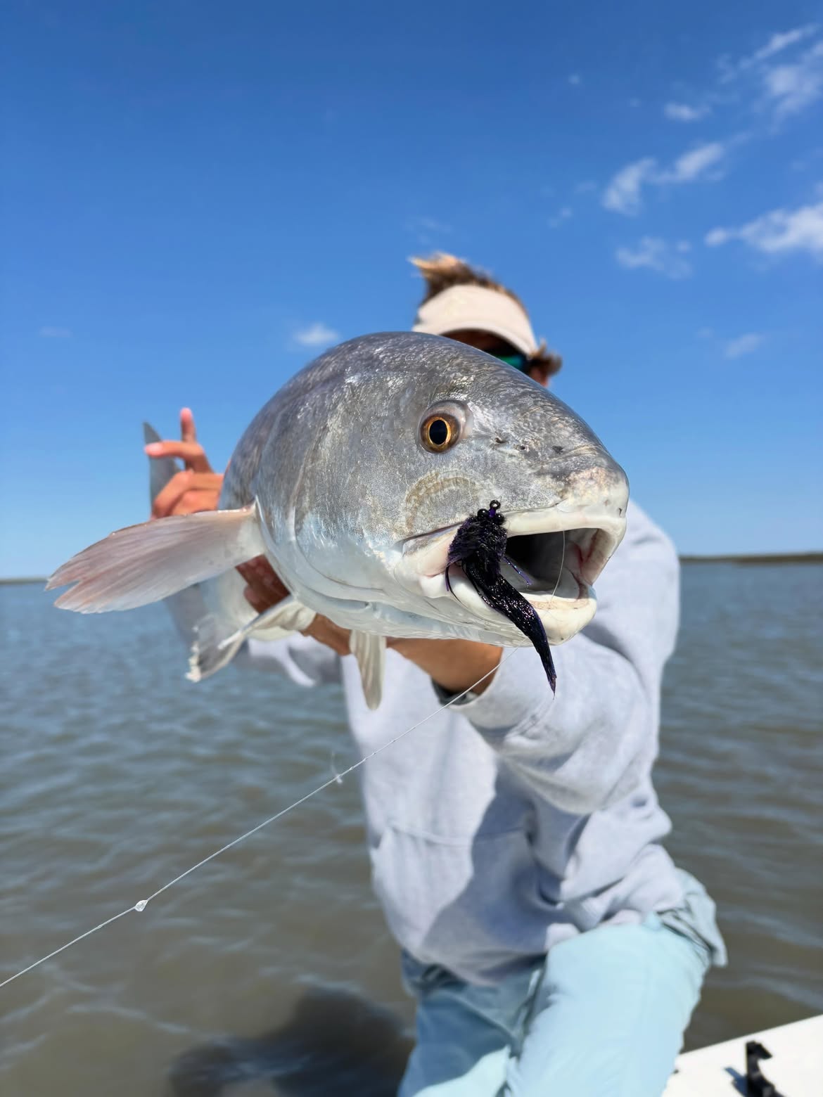 Redfish caught while fishing in Mt Pleasant SC with dark lure in mouth