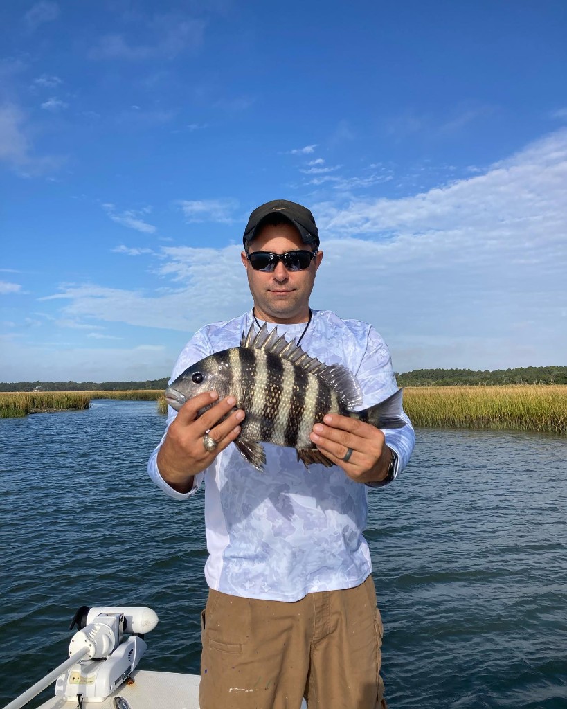 A fisherman holding a 13-inch sheepshead fish in South Carolina