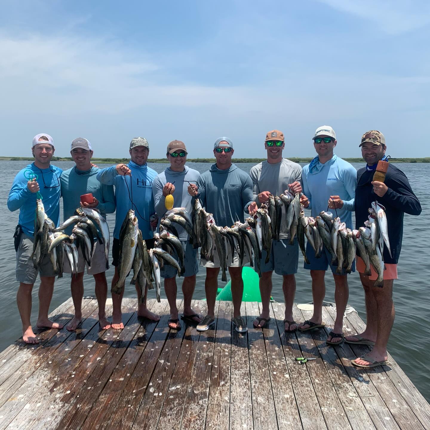 A group of 8 people fishing in Pass Christian