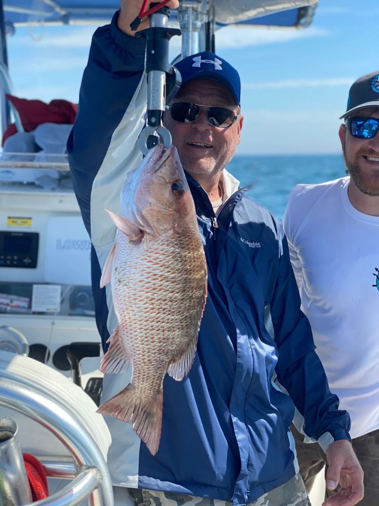 Angler holding a grey snapper fish caught in FL