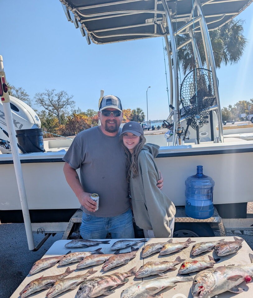 Fresh caught fish displayed on cleaning table at St. Petersburg FL fishing dock with boat in background