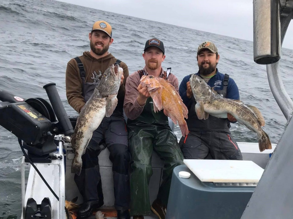 Three anglers with their catch on the shore of Fortuna