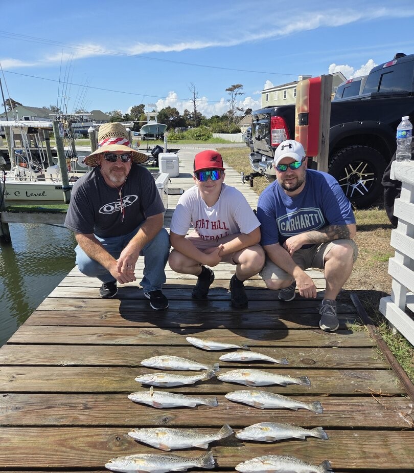 Speckled trout and redfish catch displayed on dock in Wanchese NC after successful fishing trip